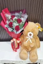 ช่อดอกกุหลาบแดงกับตุ๊กตาหมีน้ำตาล