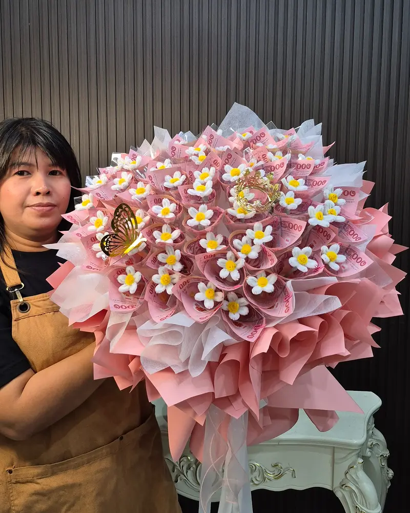 คนถือช่อเจ้าหญิงทรงกลมสีชมพูหลังใส่ธนบัตร เพื่อแสดงขนาดสินค้าจริง