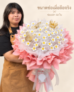เจ้าของร้านถือช่อเจ้าหญิงสีชมพูช่อเปล่าเพื่อเทียบขนาด